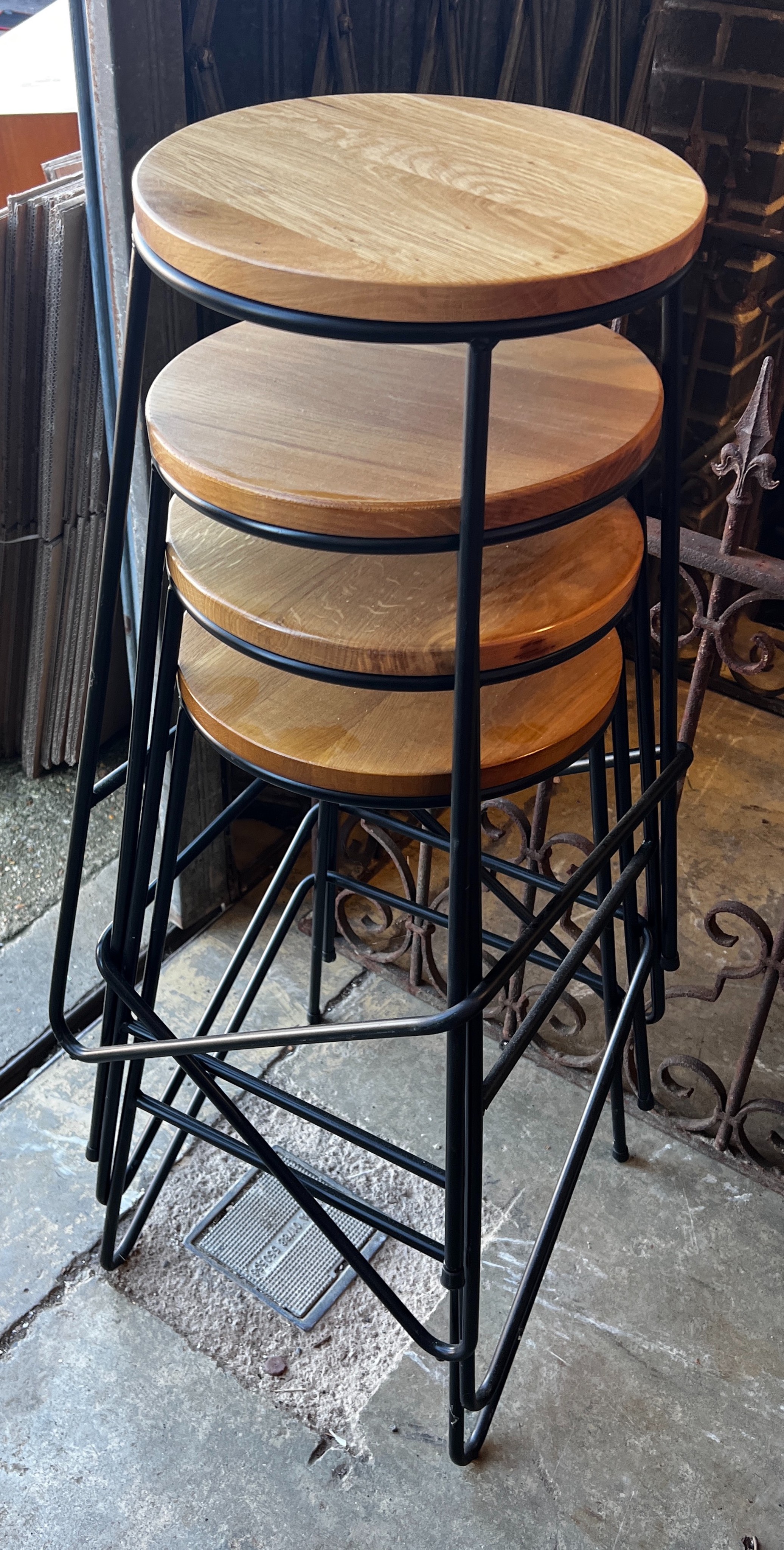 A set of four industrial style wrought iron and oak bar stools, height 70cm